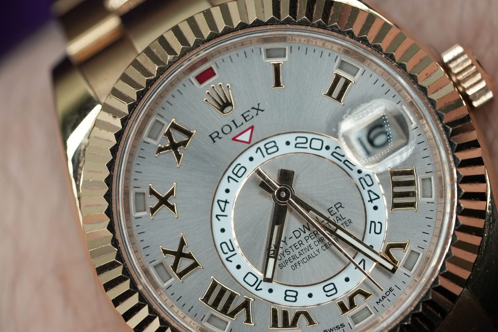 Macro of a rose gold Rolex Sky-Dweller dial on the wrist